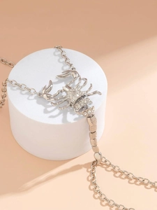 Detailed view of silver scorpion bracelet with sparkling white rhinestones on geometric stand