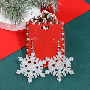 Sparkling silver glitter snowflake earrings on festive red card for Christmas jewelry