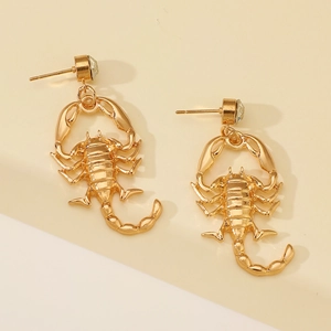 Detailed view of scorpion-shaped drop earrings with clear rhinestones in gold finish