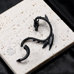 Detail shot of vintage punk black dragon ear cuff with intricate scale textures on silk
