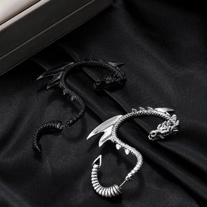Detailed close-up of gothic dragon ear cuffs in silver and black metal finishes