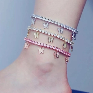 Close-up of butterfly pendant tennis anklets in silver, gold, and rose pink finishes