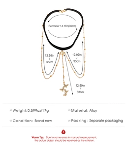 Detailansicht eines schwarzen Samt-Chokers mit goldenen Schmetterlingsanhängern und Ketten