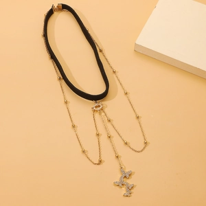 Detail eines mehrlagigen Samt-Chokers mit goldenen Schmetterlings-Kettenanhängern