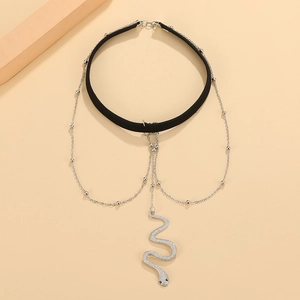 Nahaufnahme eines mehrlagigen Chokers mit einem Kristallschlangenanhänger und Silberketten