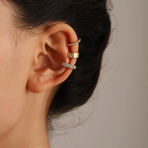 Detailed view of three gold ear cuffs featuring smooth metal and sparkling rhinestones