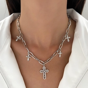 Close-up of silver layered necklace with pearl cross pendants on white shirt