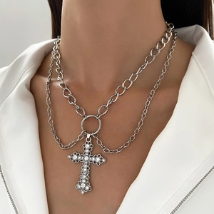 Detail of layered hip-hop necklace featuring a rhinestone cross and silver metal chains