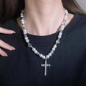 Detail of vintage pearl necklace with crystal beads and a crystal-encrusted cross pendant