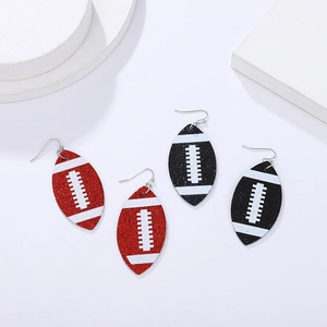 Detail of red and black glitter football earrings on geometric white props for sports style
