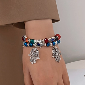 Détail d'un bracelet Hamsa multicouche avec perles à facettes et pendentifs Main de Fatma
