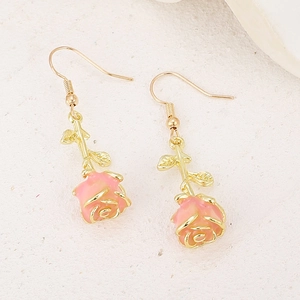 Macro shot of elegant light pink rose earrings with golden trim and metal hooks