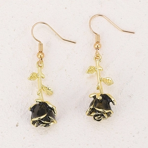 Close-up of vintage black rose earrings with golden stem and fine metallic petals