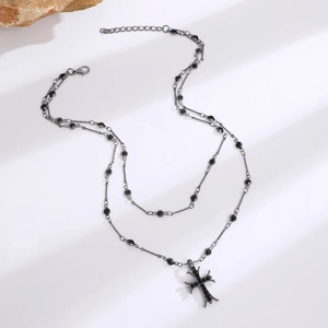 Detailed view of punk style layered necklace with black crystals and cross pendant