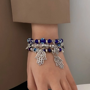 Détail d'un bracelet de perles œil bleu avec breloque main de Fatima sur un poignet