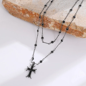 Close-up of gothic double-layer necklace with black stones and a cross pendant
