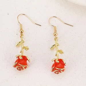 Detailed close-up of vintage rose earrings with red petals and golden stems