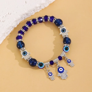 Détail des perles oeil bleu et des breloques main de Fatima sur un bracelet perlé