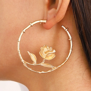 Close-up of vintage golden rose flower hoop earring worn on model's ear