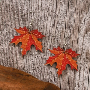 Pendientes de hoja de arce con textura de madera y degradado rojo en fondo de madera