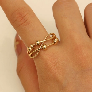 Detailed close-up of golden fidget ring featuring double layer cross design and sliding beads
