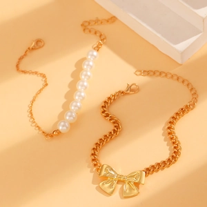 Elegantes Set aus goldener Armbandkette mit Schleifenanhänger und weißen Perlen für Damen