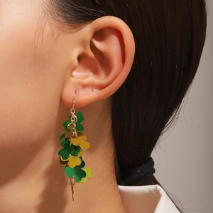 Saint Patrick's Day shamrock dangle earrings with green and gold sequins on female model