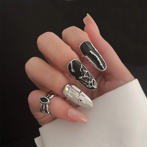 Punk style silver armored nail ring set with cross and eye motifs on black background