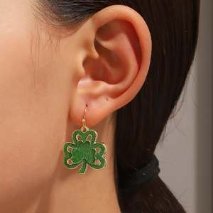 Detalle de pendientes de trébol para San Patricio con esmalte verde brillante y oro