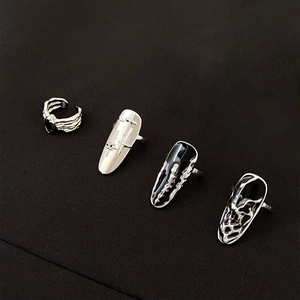 Macro detail of S925 sterling silver nail rings with punk gothic cross and lava texture