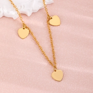 Detailaufnahme einer goldenen zweilagigen O-Kette mit drei polierten Herzanhängern