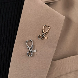 Detail of stethoscope brooch in silver and gold pinned on a brown suit lapel