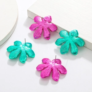 Detail shot of oversized metallic flower earrings in magenta and green with radial textures