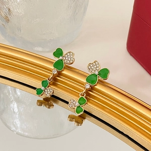 Detalle de los pendientes de trébol de San Patricio con esmalte verde y cristales brillantes