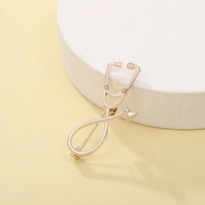 Detalle de broche de estetoscopio oro claro en soporte redondo con textura metálica nítida