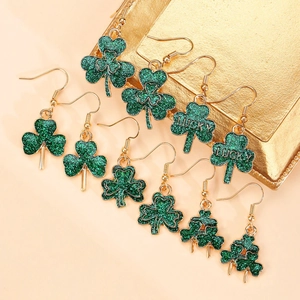 Detalle de pendientes de San Patricio con trébol verde y amuletos de suerte