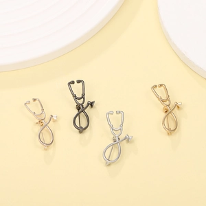 Detalle de broches de estetoscopio en oro, plata, oro rosa y aleación negra pulida