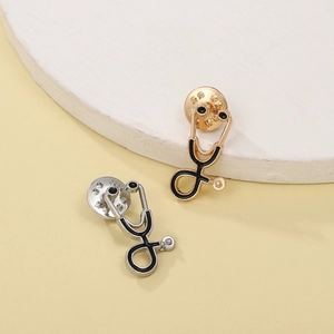 Detailed view of stethoscope lapel pins with gold and silver finish and butterfly clutches