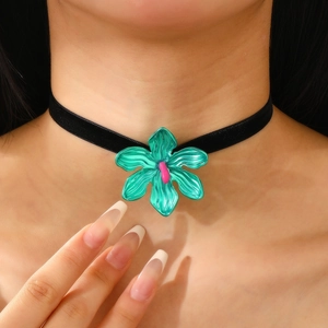 Vista detallada del choker de terciopelo negro con un gran colgante de flor verde