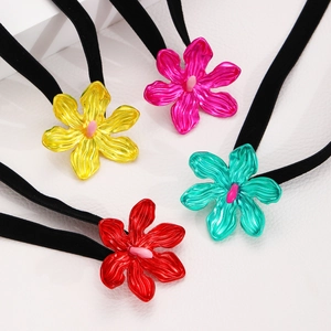 Detalle de pendientes de flores de aleación colorida sobre fondo de cuero blanco texturizado