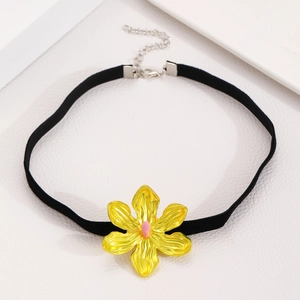 Primer plano de un colgante de flor amarilla grande en un choker negro con cierre plateado
