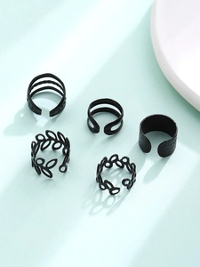 Detail view of five matte black vintage ear cuffs featuring hollow leaf and layered designs