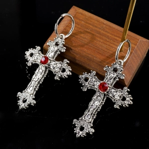 Detail view of retro antique silver cross earrings with red gemstone and baroque relief