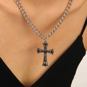 Macro view of Gothic silver alloy cross pendant with black gemstone on thick chain
