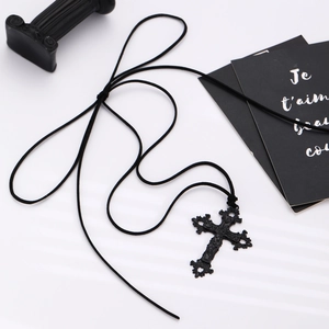Detailed close-up of Gothic black cross necklace with ornate vine embossed patterns