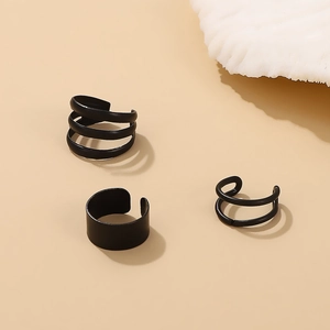 Macro detail of three-piece matte black ear cuff set with spiral and wide band designs