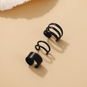 Detail of three matte black ear cuffs featuring smooth band and spiral wire designs