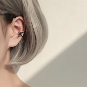 Close-up of black bat ear cuff worn on the ear bone, gothic style jewelry for men and women