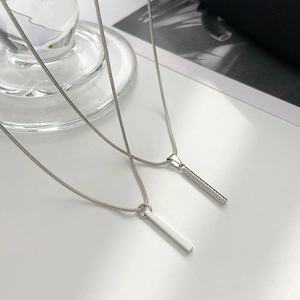 Minimalist silver hip hop pillar pendants with snake chains on a modern background