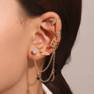 Detailansicht der goldfarbenen Schmetterlings-Ohrringe mit Stern-Mond-Kette und Strass